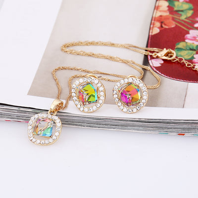 Gold-colored necklace and stud earrings set with iridescent multi-faceted crystal pendants surrounded by clear crystals. - Image 4