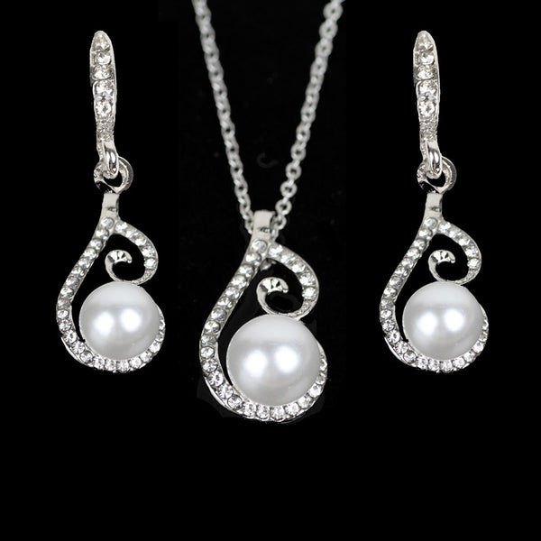 Silver-tone rhinestone and faux pearl drop necklace and matching earrings jewelry set on a black background.