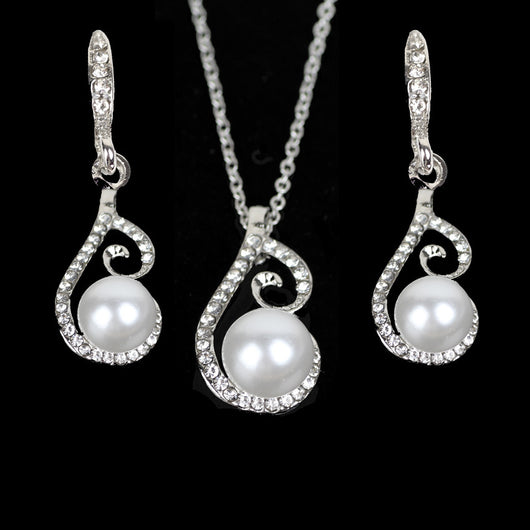 Silver-tone rhinestone and faux pearl drop necklace and matching earrings jewelry set on a black background.