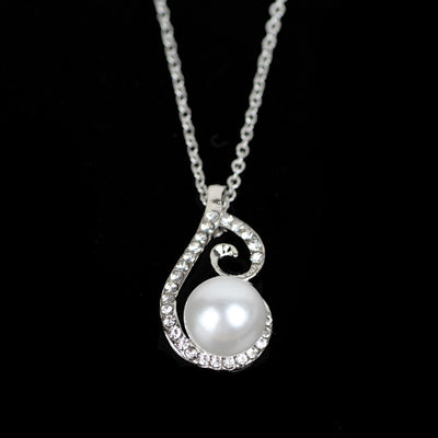 Silver-tone rhinestone and faux pearl drop necklace and matching earrings jewelry set on a black background. - Image 2