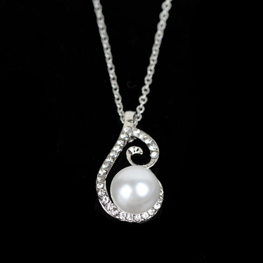 Silver-tone rhinestone and faux pearl drop necklace and matching earrings jewelry set on a black background. - Image 2