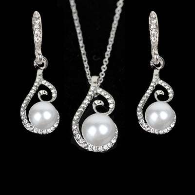 Silver-tone rhinestone and faux pearl drop necklace and matching earrings jewelry set on a black background. - Image 4