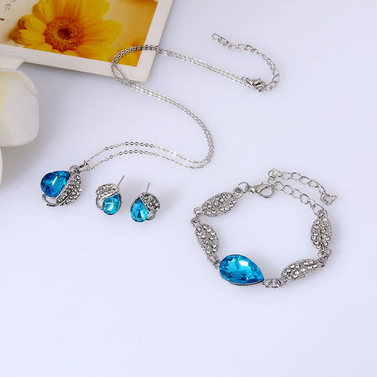 Silver-tone jewelry set with teardrop blue gemstones and clear rhinestones, including a necklace, bracelet, and earrings. - Image 5