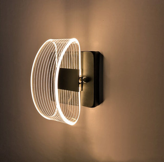 Modern simple LED wall lamp with a curved clear acrylic shade and a metallic base, emitting a warm light. - Image 10