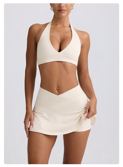 Light pink halter neck sports bra and high-waisted leggings workout set on a model. - Image 41