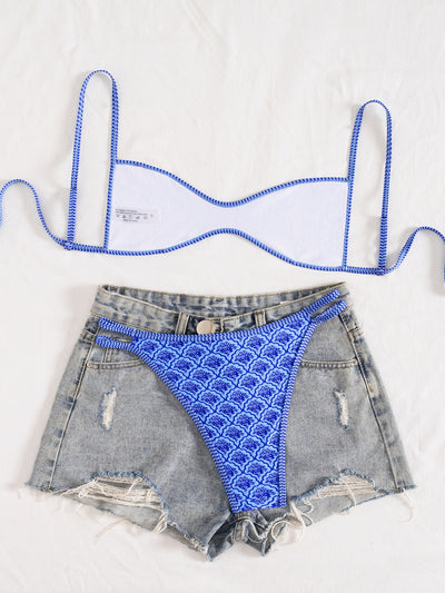 Black bandeau bikini swimsuit with thin straps and a gold-toned abstract ring detail on the top, paired with matching string bottoms. - Image 34