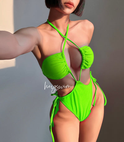 Black drawstring one-piece swimsuit with a ruched halter top and high-cut, tie-side bottom on a woman. - Image 7