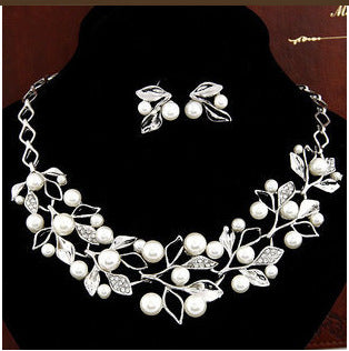Gold-toned necklace and matching earrings set with faux pearls and clear rhinestones in an elegant leaf and vine design. - Image 10