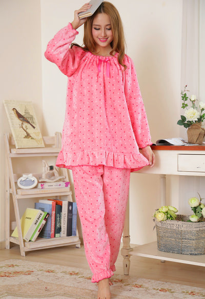 Young woman wearing a pink coral fleece thermal pajama set with white and red polka dots and ruffled hems. - Image 8