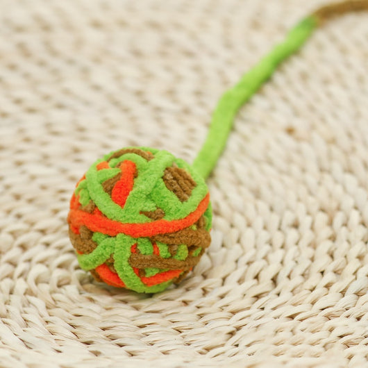 Colorful plush yarn ball cat toy in pink, blue, and white, with a long trailing strand, on a light background. - Image 15