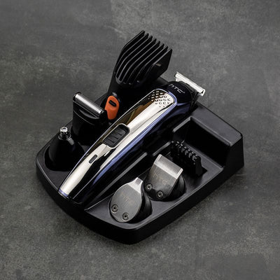 Five-in-one HTC electric hair clipper set with multiple attachments and a black charging stand on a dark background.