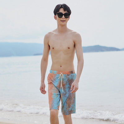 Men's or unisex swim shorts with a blue, orange, and brown abstract tie-dye print, featuring a drawstring waist and side pockets. - Image 4