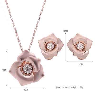 Rose gold-toned necklace and stud earrings set with floral design and clear rhinestone accents. - Image 3