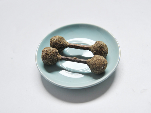 Three dumbbell-shaped catnip and silvervine chew toys with natural wood sticks on a light blue plate. - Image 3