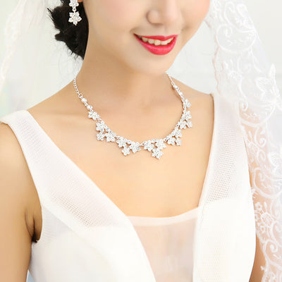 Sparkling crystal bridal jewelry set with floral necklace, drop earrings, and a matching tiara on a bride. - Image 5