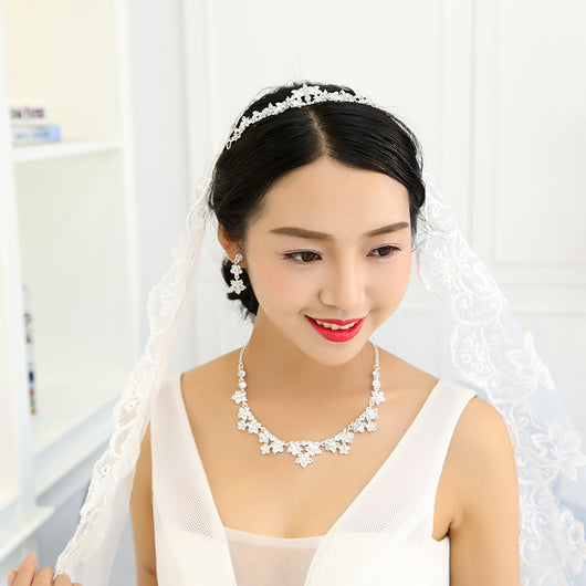 Sparkling crystal bridal jewelry set with floral necklace, drop earrings, and a matching tiara on a bride. - Image 3