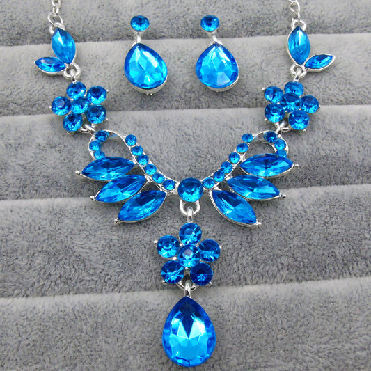 Purple rhinestone statement necklace with silver-tone setting, featuring floral and leaf motifs and a teardrop pendant.