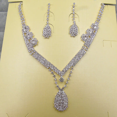 Sparkling silver-toned bridal necklace and matching drop earrings set with clear rhinestones. The necklace features a V-shape and a teardrop pendant, while the - Image 3