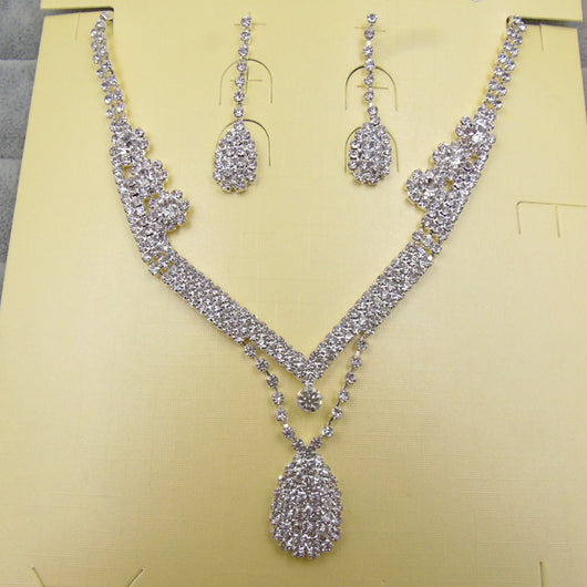 Sparkling silver-toned bridal necklace and matching drop earrings set with clear rhinestones. The necklace features a V-shape and a teardrop pendant, while the - Image 3