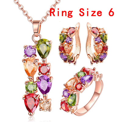 Shiny rose gold-tone necklace, earrings, and ring set with multi-colored teardrop and round zircon stones. Ring size 9.