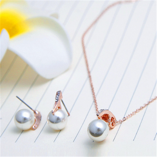 Rose gold-toned necklace and stud earrings set with faux pearls and clear rhinestones, displayed on a white background. - Image 5