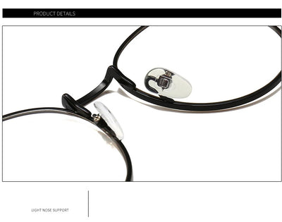 Black round anti-blue light glasses with clear lenses showing a blue reflection, resting on a gray textured surface. - Image 13