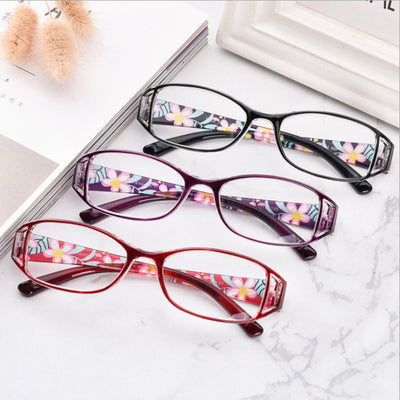 Women's lightweight fashion reading glasses with a red frame and colorful floral print temples.