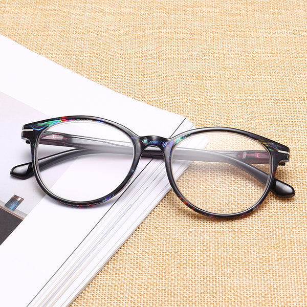 Four pairs of anti-blue light reading glasses with colorful full-rim frames in pink, tea, blue, and violet patterns.