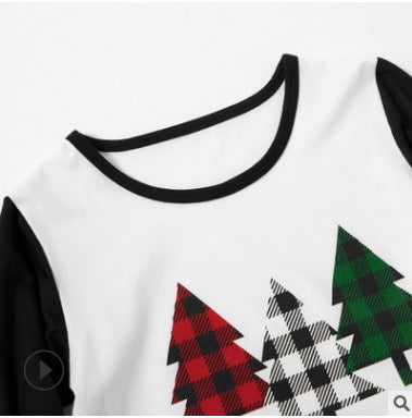 Matching family Christmas pajamas with white tops, black sleeves, buffalo plaid trees, and 'be merry' text. - Image 3