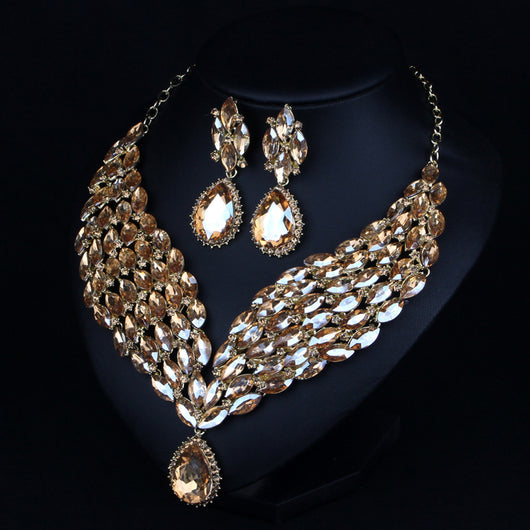 Green and teal rhinestone necklace and matching dangle earrings set on a black jewelry stand. - Image 2