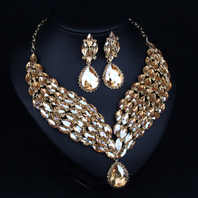 Green and teal rhinestone necklace and matching dangle earrings set on a black jewelry stand. - Image 3