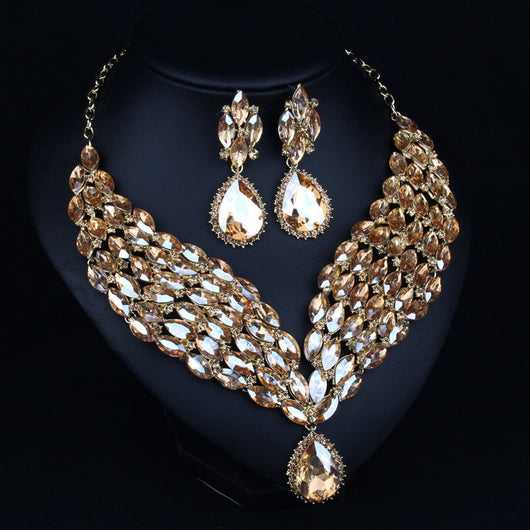 Green and teal rhinestone necklace and matching dangle earrings set on a black jewelry stand. - Image 3