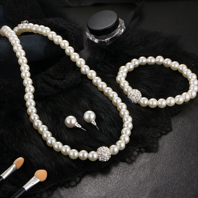 White pearl necklace, bracelet, and stud earrings set with pave crystal ball accents, displayed on a black stand. - Image 3