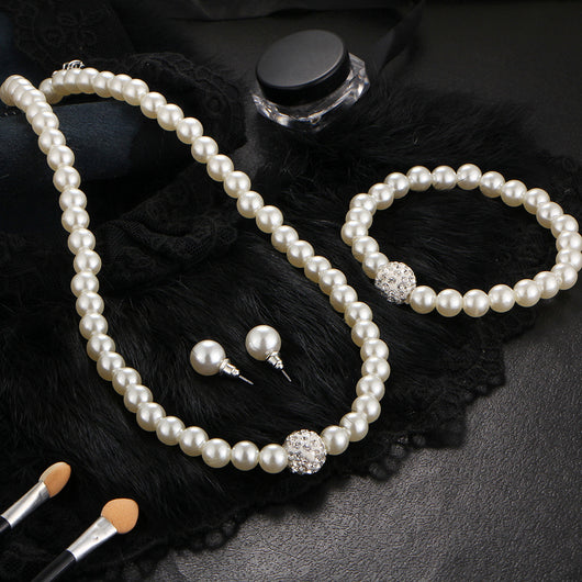 White pearl necklace, bracelet, and stud earrings set with pave crystal ball accents, displayed on a black stand. - Image 3