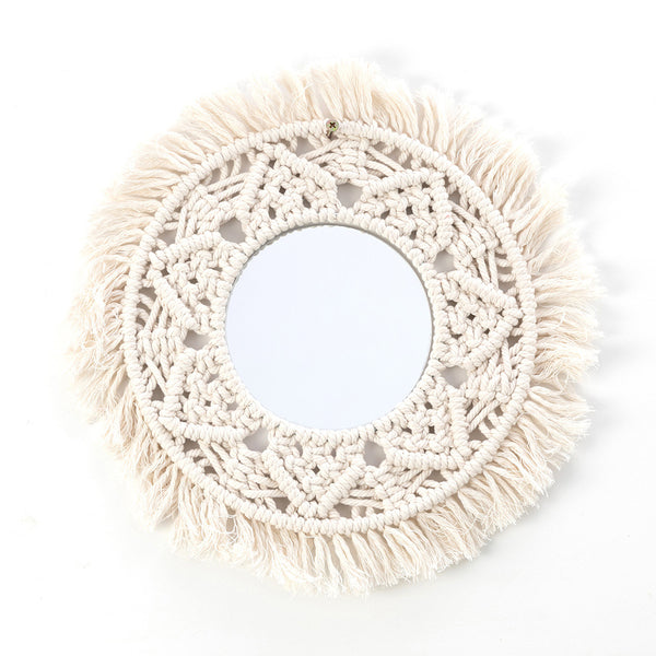 Circular mirror with a beige macrame fringe border, featuring intricate knotwork around the reflective surface.