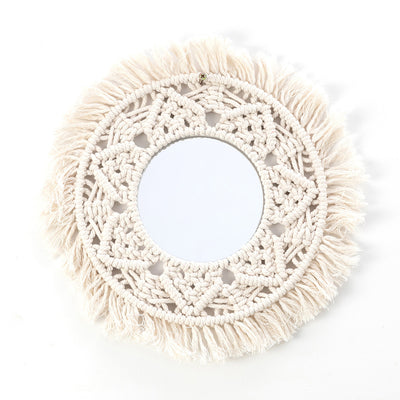 Circular mirror with a beige macrame fringe border, featuring intricate knotwork around the reflective surface.