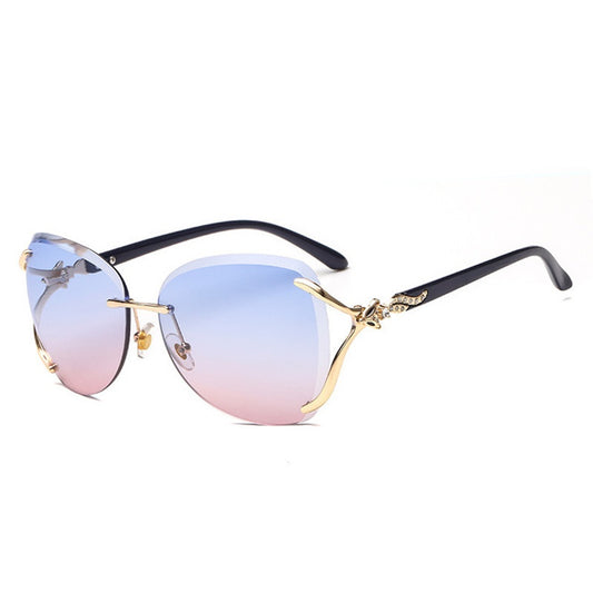 Oversized rimless sunglasses with gradient gray lenses and silver-tone metal accents, displayed on a white surface.