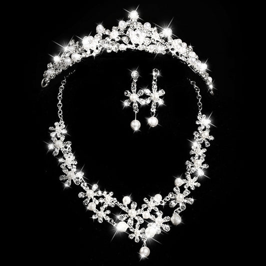 Bridal jewelry set with a silver-tone necklace and matching drop earrings, featuring crystal flowers and faux pearls.