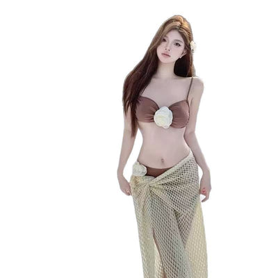 Brown two-piece bikini with white floral embellishments and a sheer beige mesh sarong modeled outdoors. - Image 5