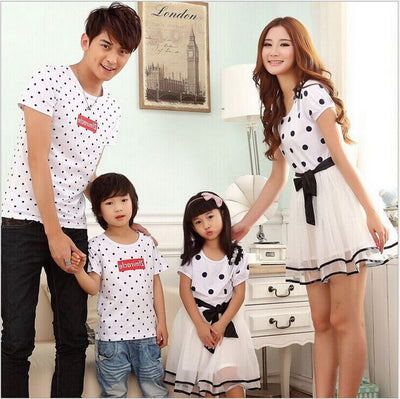 Family of four wearing matching white and black polka dot outfits. Dad and son in t-shirts, mom and daughter in dresses. - Image 13