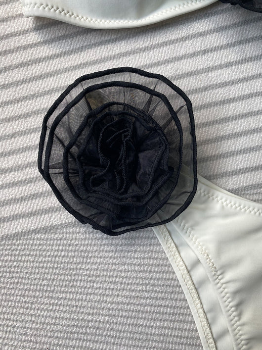 Black tube top bikini with white three-dimensional flower embellishments, worn by a woman partially submerged in water. - Image 20