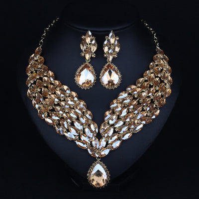 Green and teal rhinestone necklace and matching dangle earrings set on a black jewelry stand. - Image 6