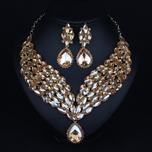 Green and teal rhinestone necklace and matching dangle earrings set on a black jewelry stand. - Image 6