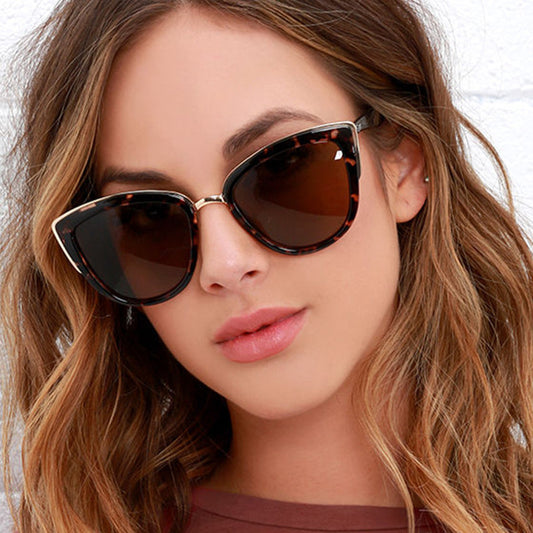 Black cat-eye sunglasses for women with gradient grey lenses and subtle gold-tone metal accents on the frame.