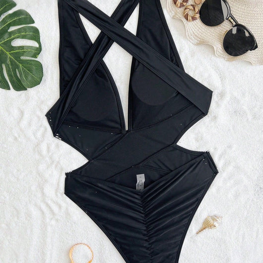 Woman in a black one-piece swimsuit with a deep V-neck and criss-cross waist cutouts, wearing a straw hat. - Image 5