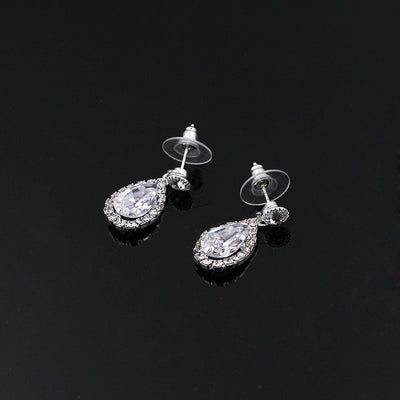 Sparkling silver-toned necklace and matching teardrop earrings set with clear stones, displayed on a black stand. - Image 3