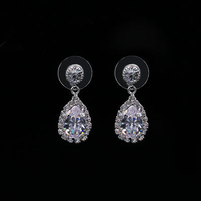 Sparkling silver-toned necklace and matching teardrop earrings set with clear stones, displayed on a black stand. - Image 2