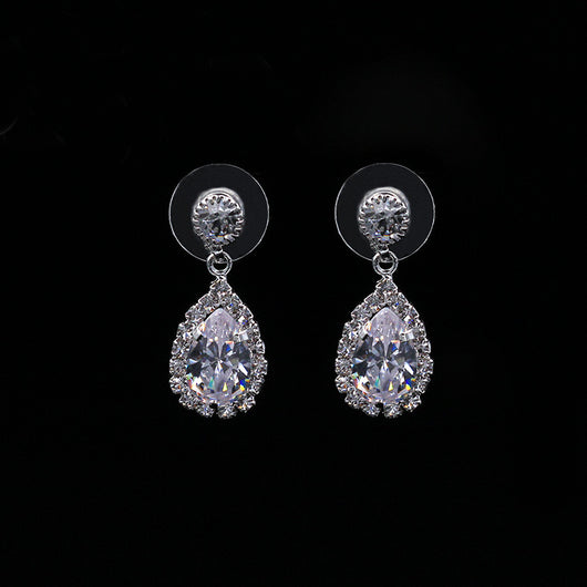 Sparkling silver-toned necklace and matching teardrop earrings set with clear stones, displayed on a black stand. - Image 2
