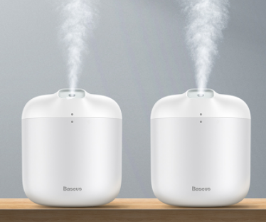 White Baseus car small elephant atomizer actively misting, shown on a wooden surface with a green leaf. - Image 5