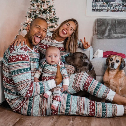 Family of four wearing matching Christmas pajamas with red, green, and white Fair Isle reindeer and snowflake pattern. - Image 3